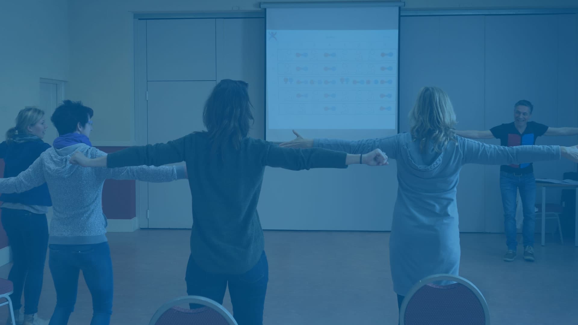 Trainer voor een groep cursisten, gezien op de rug